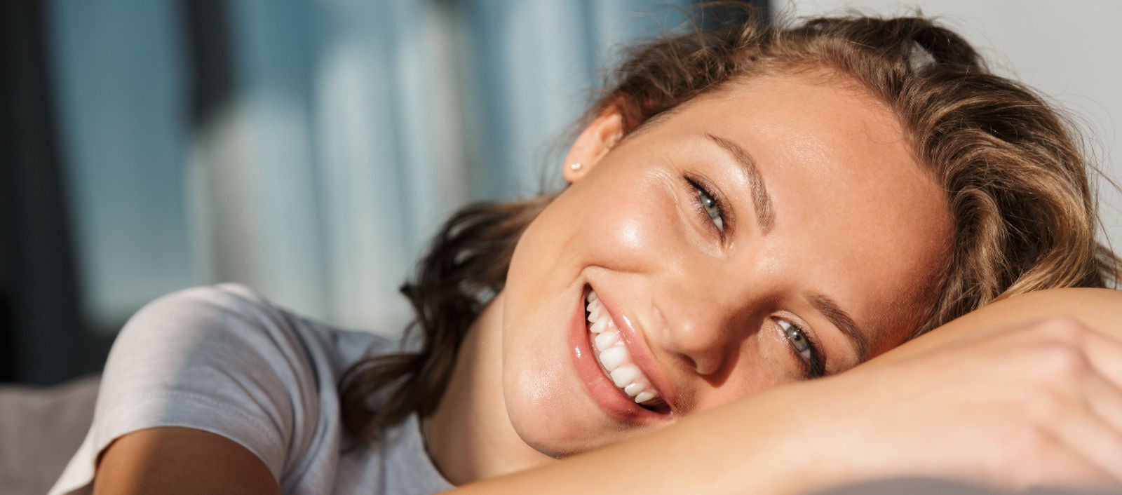 Šťastná žena ležiaca na slnku s lesklou pokožkou.